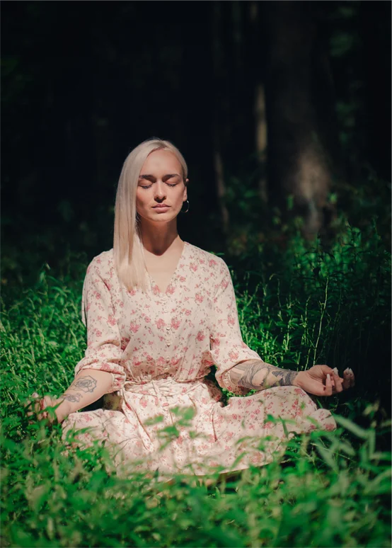 Woman meditating outdoors representing calm and nervous system regulation
